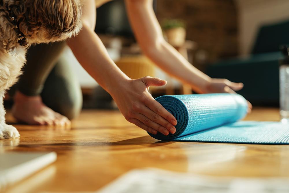 closeup-athletic-woman-preparing-sports-training-unrolling-her-exercise-mat-floor